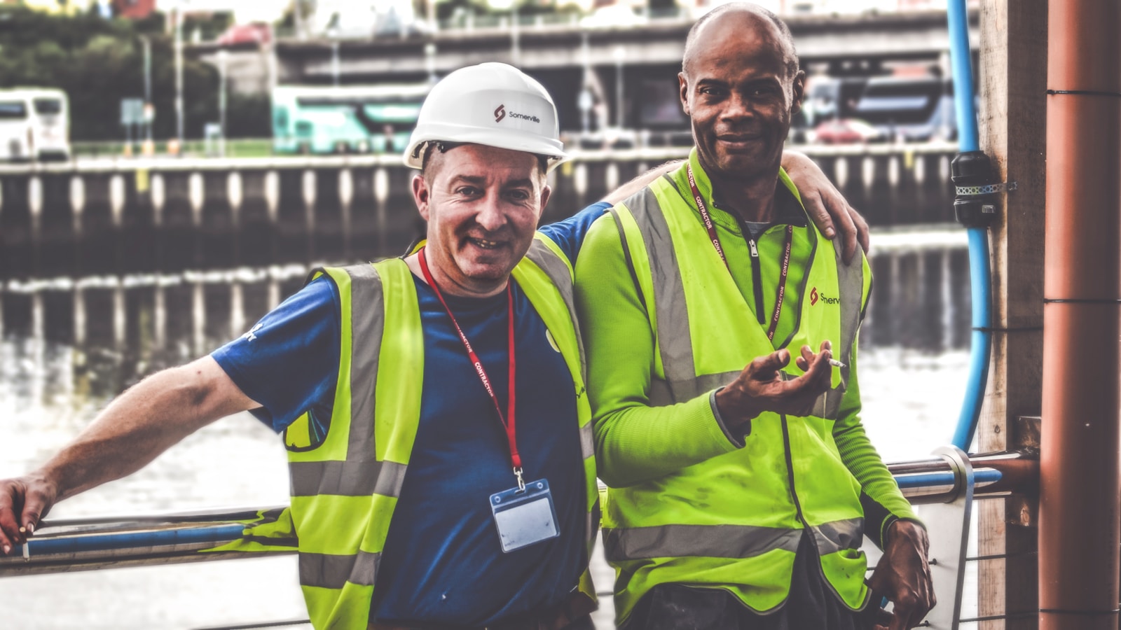 selective focus photography of two men with workers' compensation insurance  standing side by side wearing green reflective vests